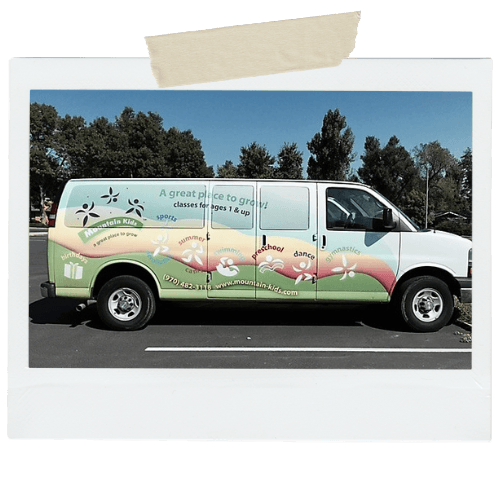 The Mountain Kids van, painted with a rainbow wave and ‘A great place to grow!’