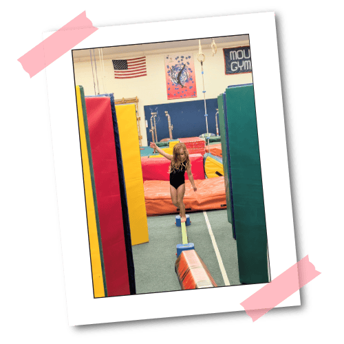A young gymnast walking the low beam